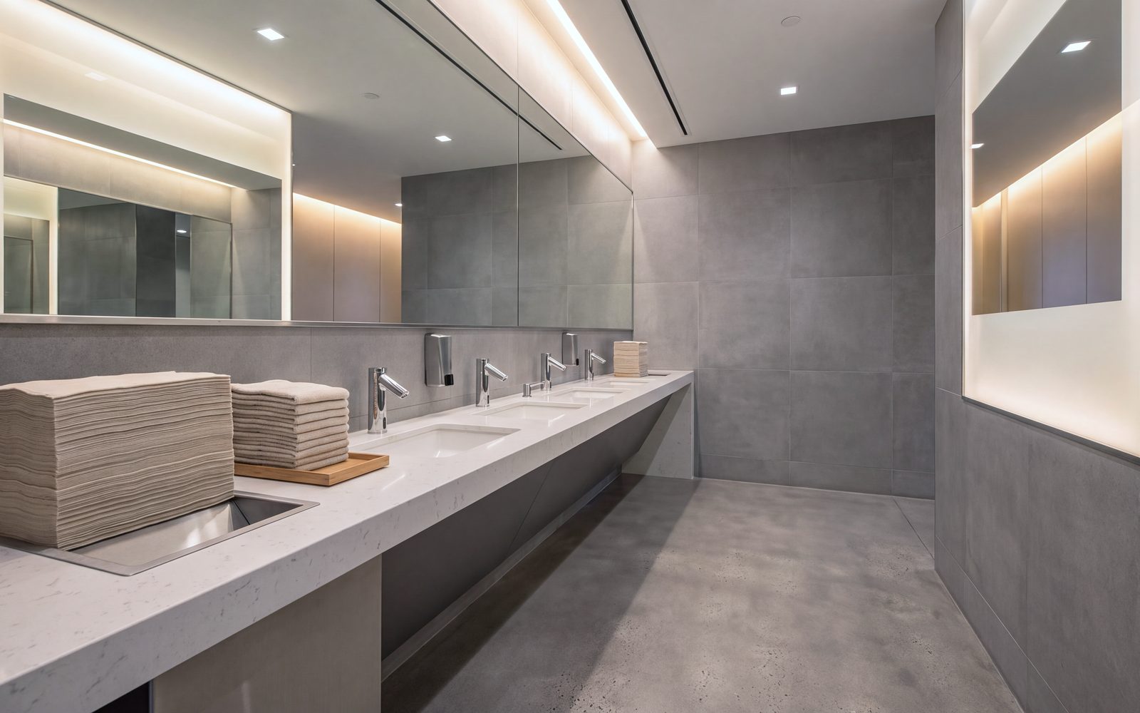 A maintained commercial restroom: vanity, mirrors and polished concrete floor